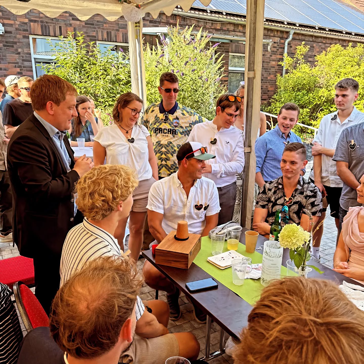Mann im Anzug zaubert für Gäste am Tisch.