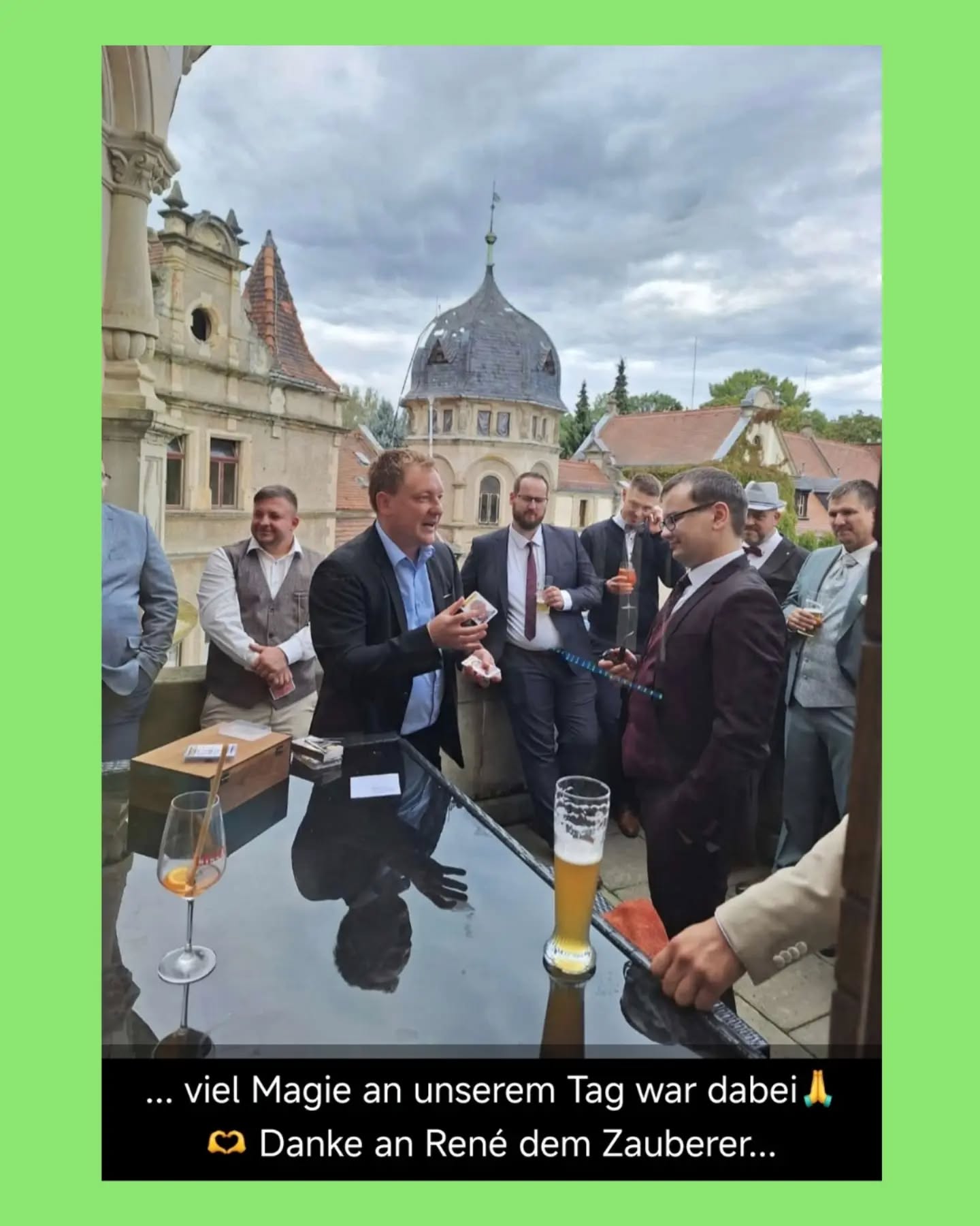 Mann im Anzug zaubert für Gäste am Tisch.